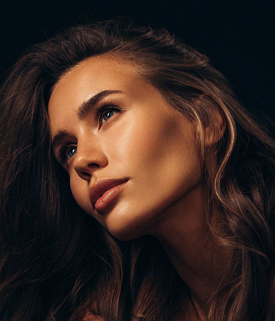 Melbourne facial cosmetic surgery model with long hair and striking features.