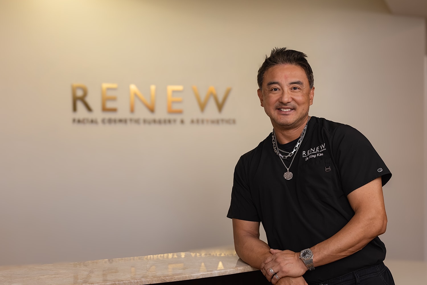 Dr. King Kim in front of RENEW cosmetic surgery sign.